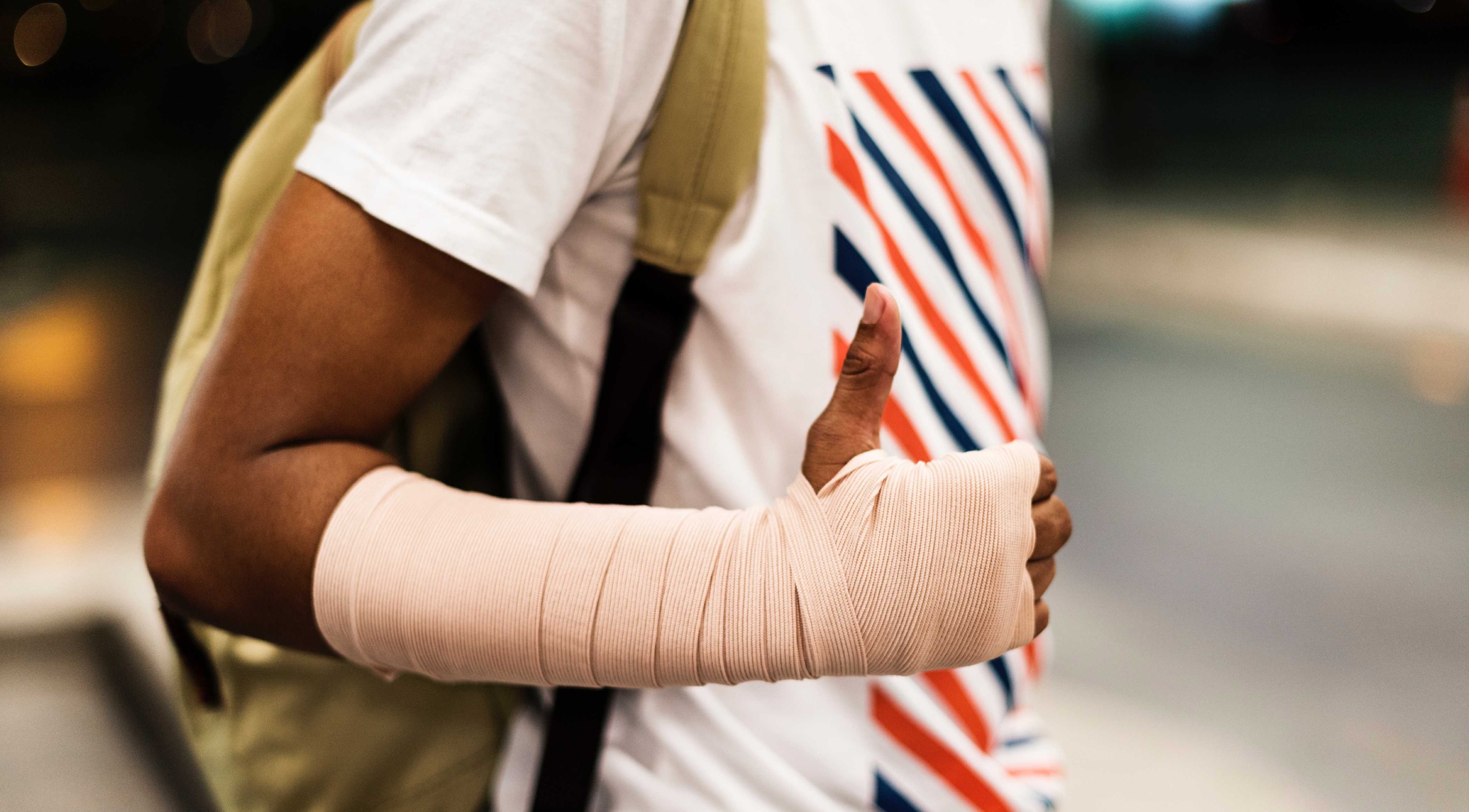 Junge mit gebrochenem Arm der den Unfall mit einer App meldet.
