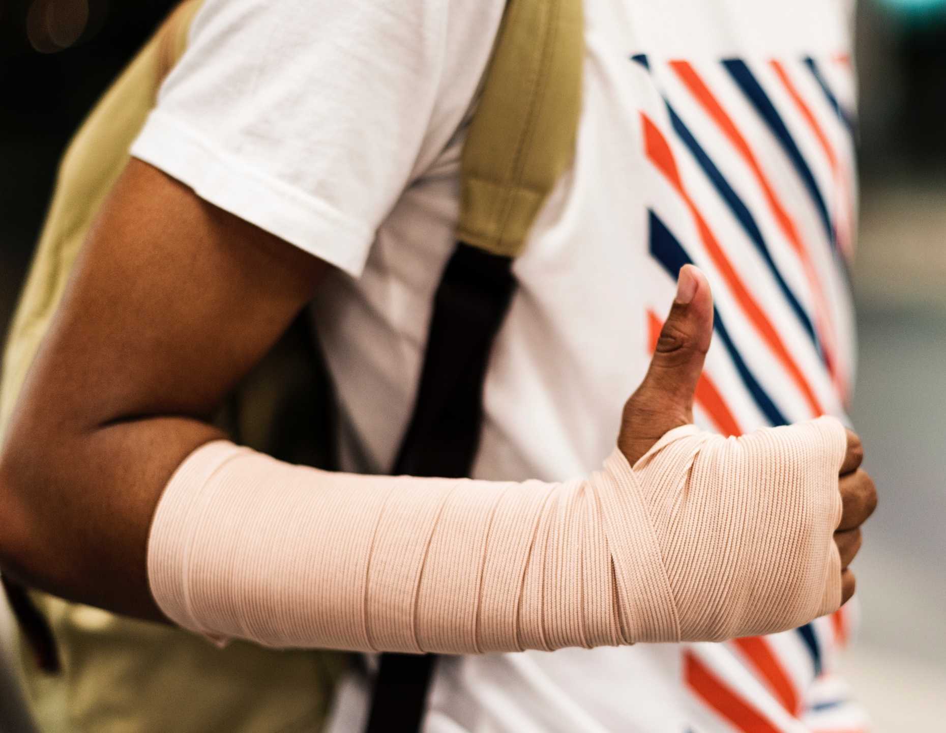 Junge mit gebrochenem Arm der den Unfall mit einer App meldet.