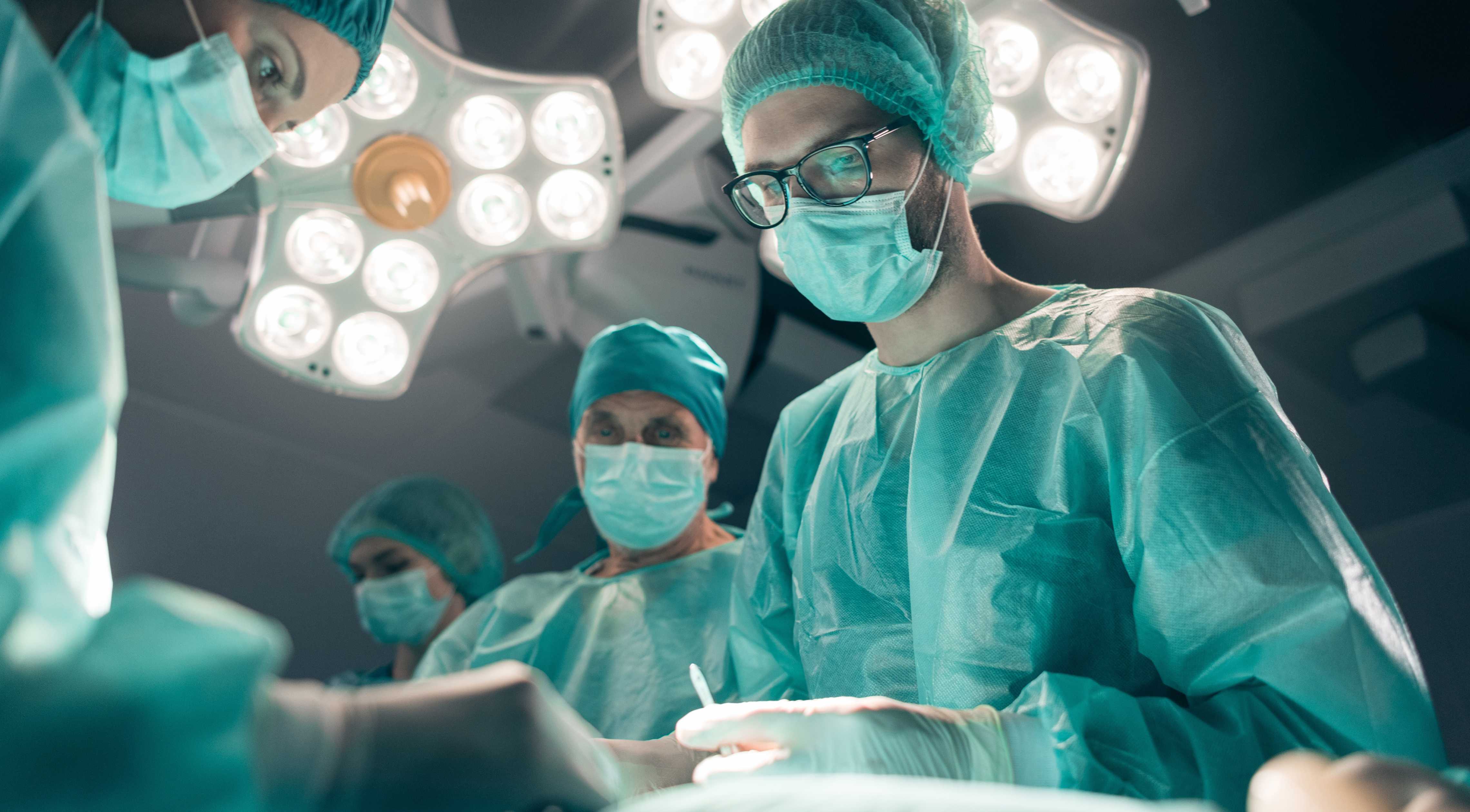 Cover einer UX-Design-Fallstudie, die Chirurgen im Operationssaal mit Lichtern an der Decke zeigt.